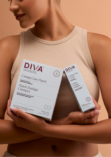 Woman holding two boxes of Diva Cramp Care Patch and Cramp Care Cream against a beige background